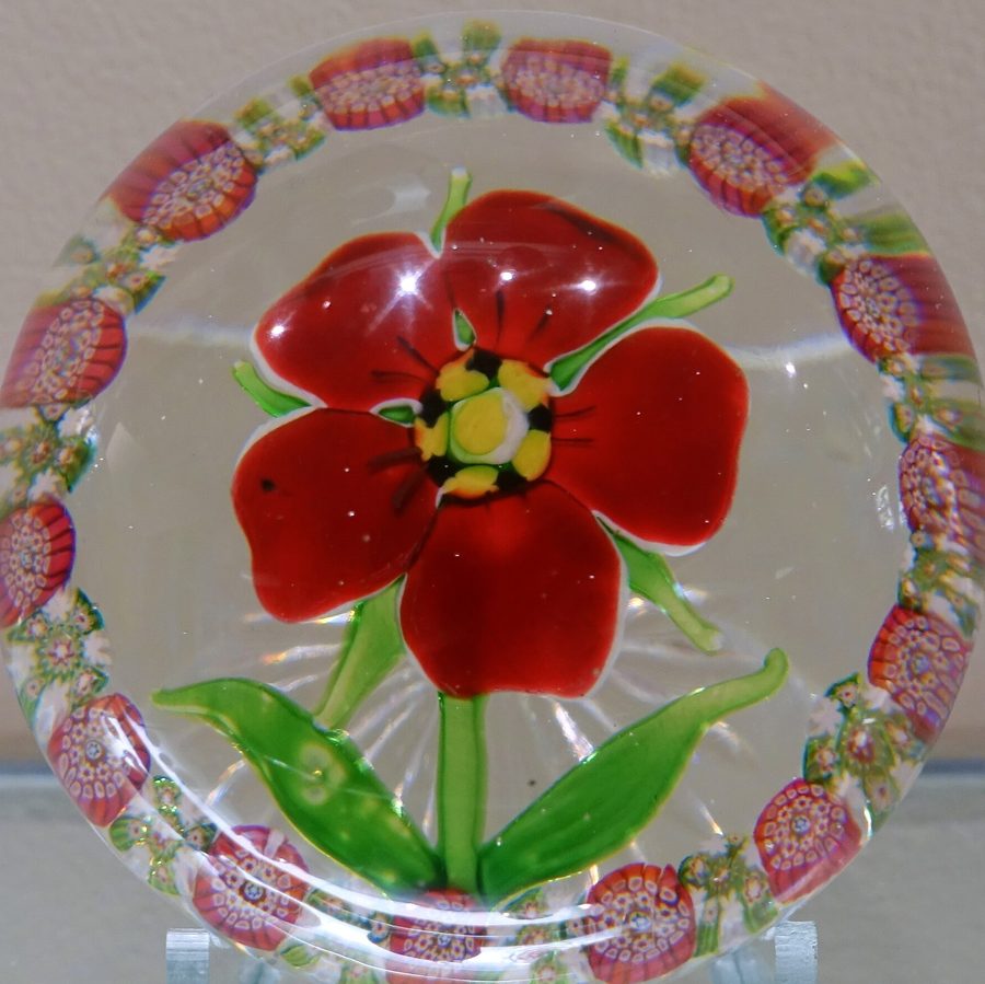 Presse-papier en cristal de Saint-Louis : une fleur rouge sur fond de filigrane blanc, cerclée de motifs roses